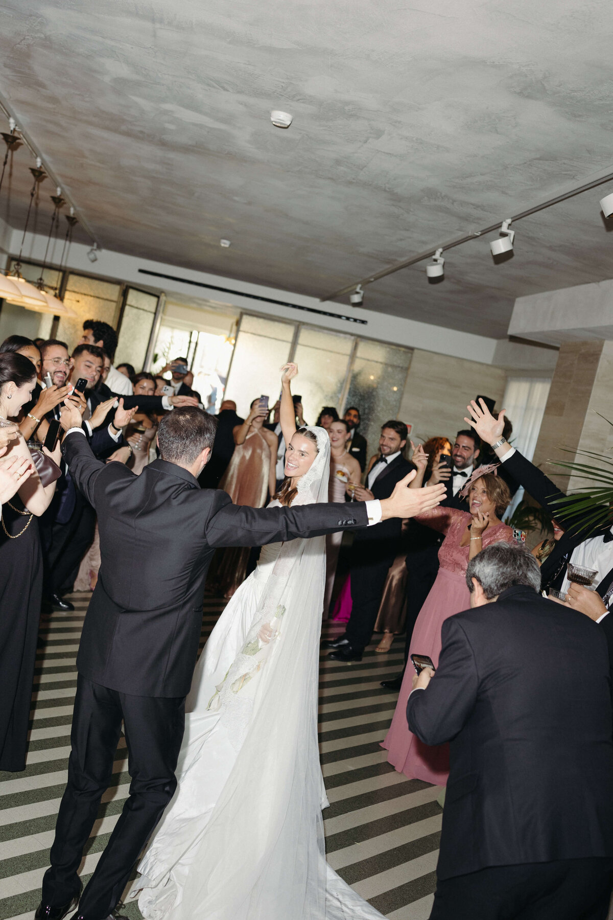 Wedding guests cheering as newlyweds enter Soho House Rome reception

