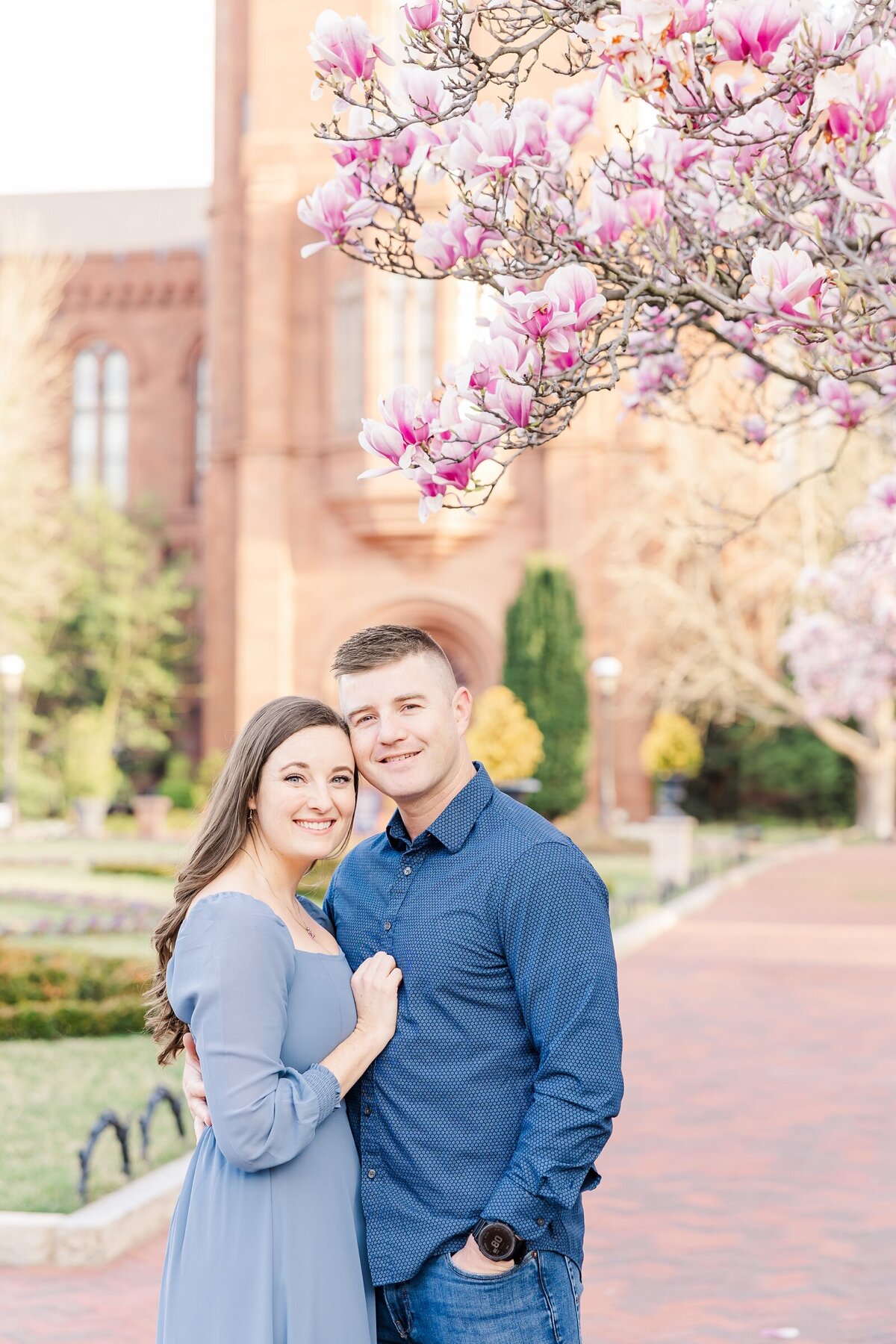 Parents standing near a flowering magnolia tree