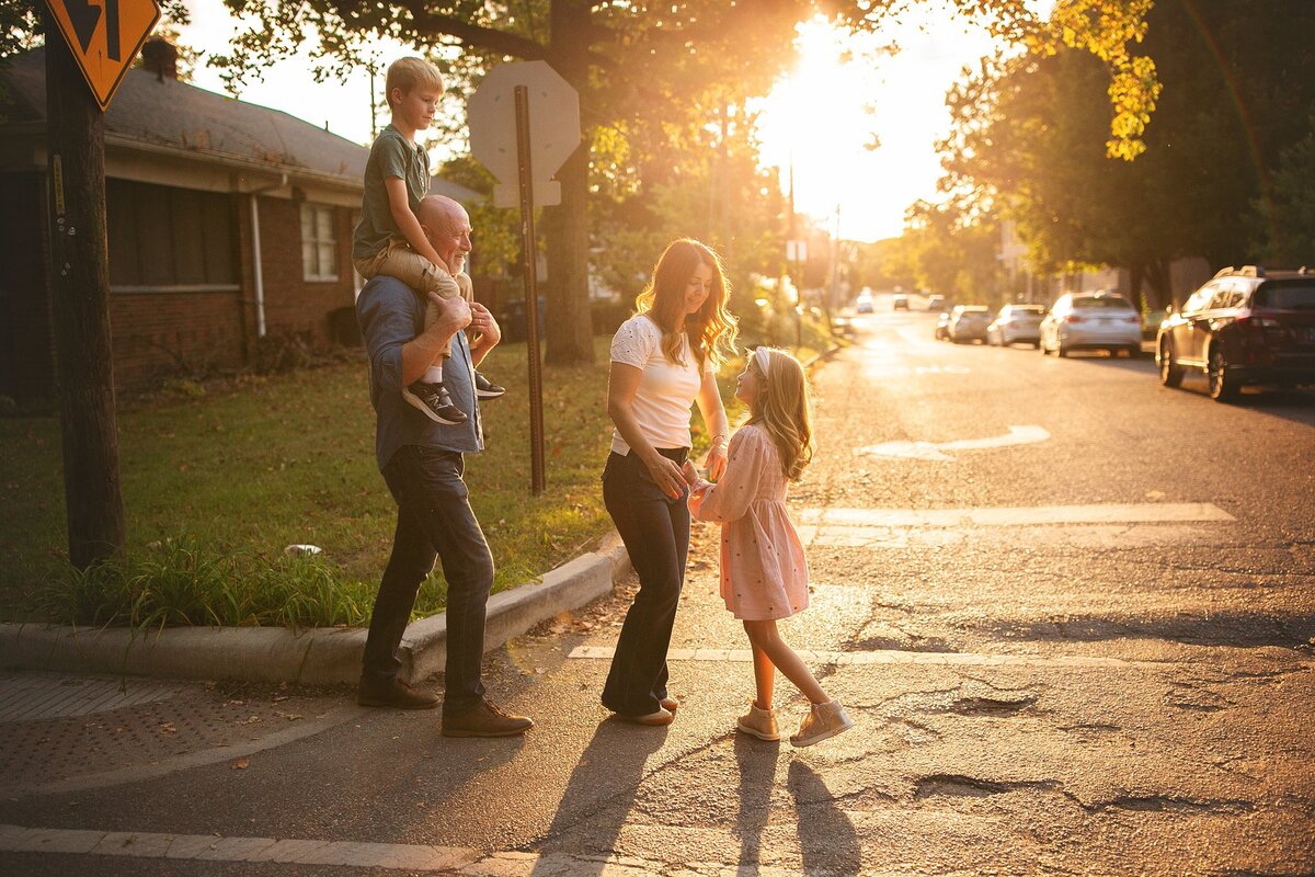 A-family-walking-across-a-street-in-the-broad-ripple-area-of-indianapolis-during-golden-hour-near-the-iconic-flower-mural-creating-a-beautiful-urban-backdrop
