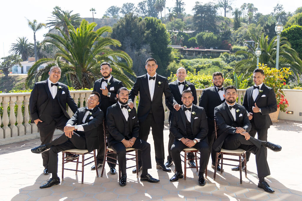 Groom with groomsman all wearing black tuxedos and black bow tie