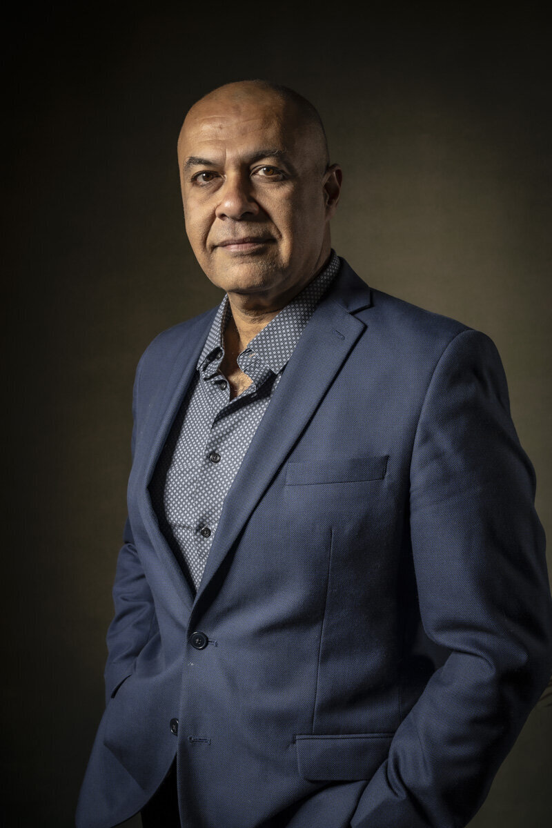 Business headshot in CT of man in blue suit jacket and patterned shirt, smiling by Rob Faber Photography.