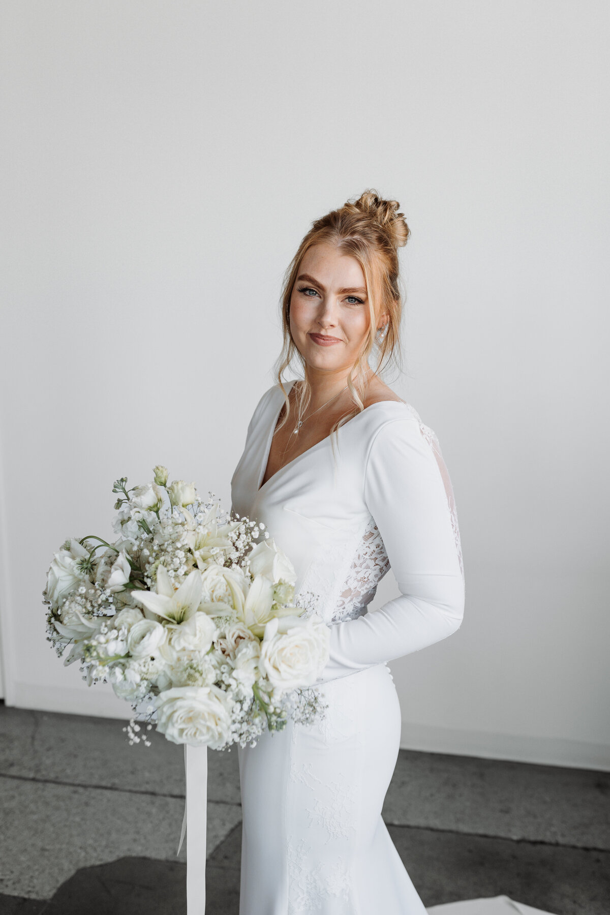 Bride holding a floral bouquet, radiating elegance, captured by Ryann B Photography, serving Indianapolis and beyond.