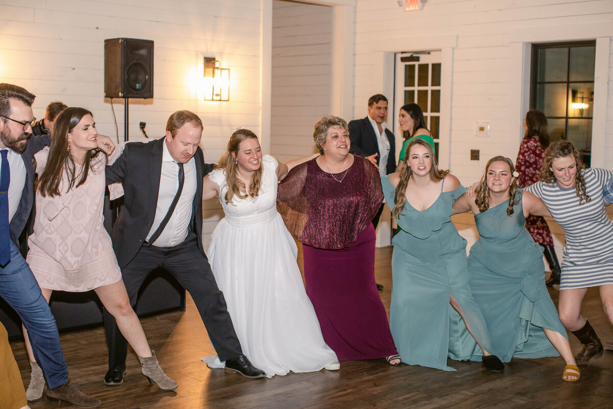 Fort Worth wedding Aggie war hymn wedding guests arm in arm on dance floor