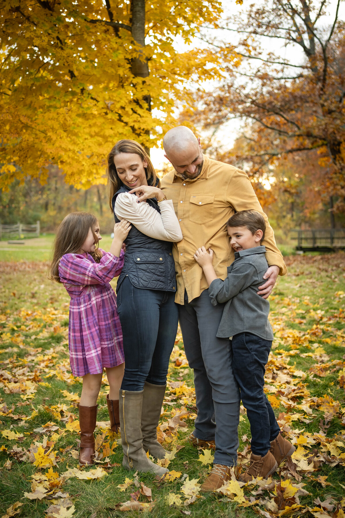 Family standing in the middle of yellow leaves