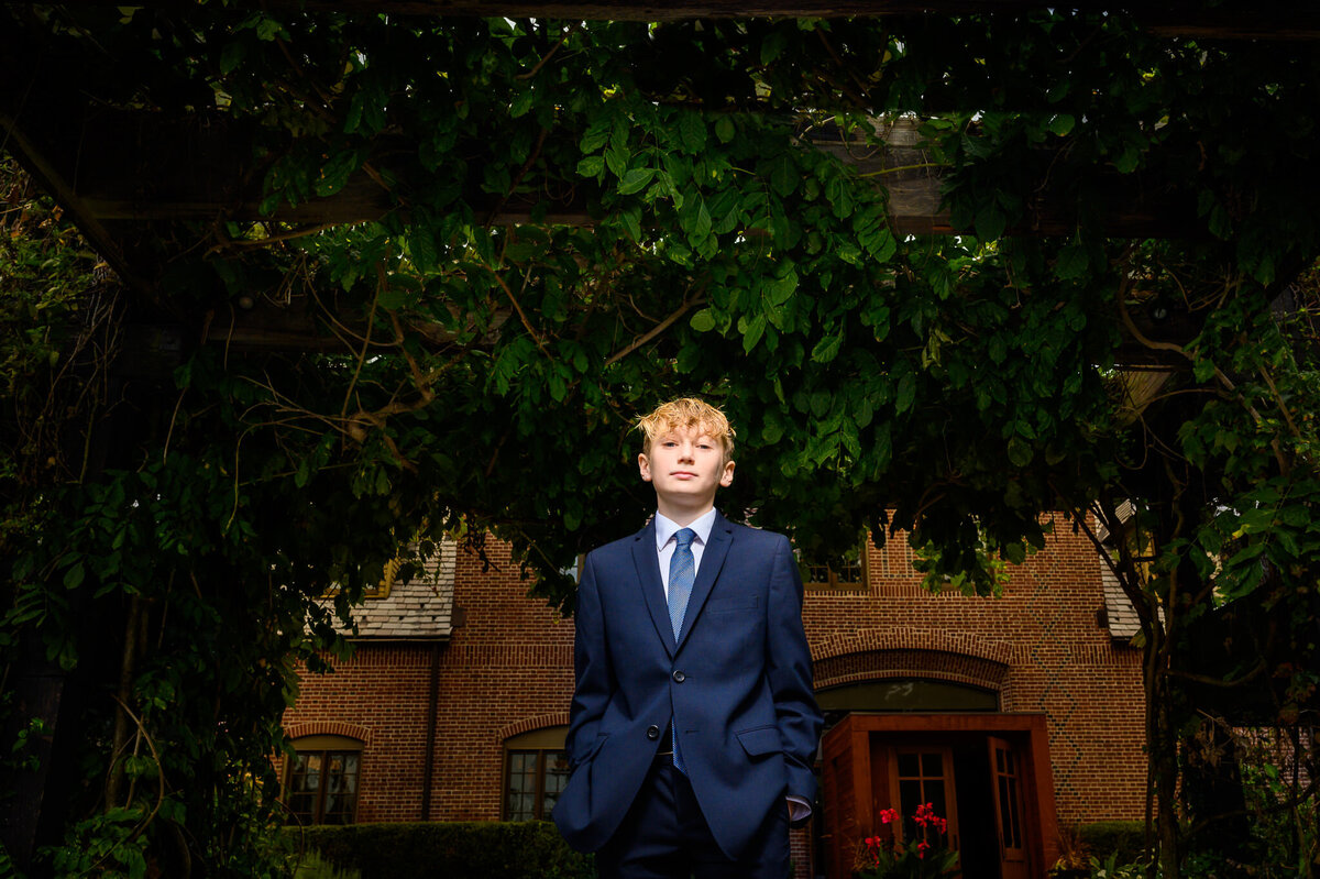 A young boy in a suit poses for his bar mitzvah photos