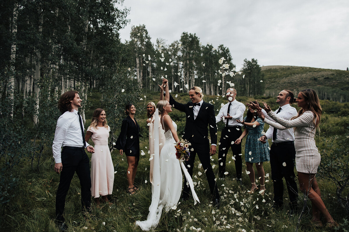 bride-and-groom-celebrating-with-family-in-field