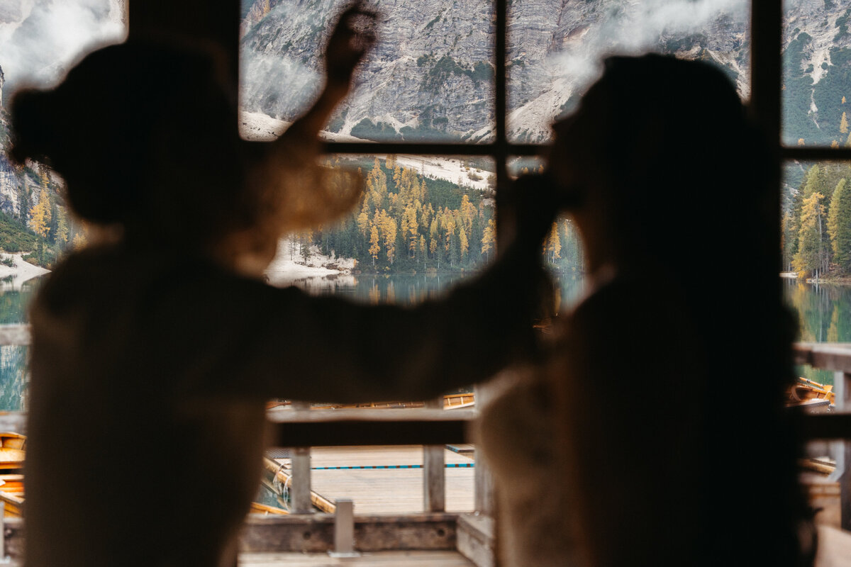 Silhouette of bride getting hair styled in cabin