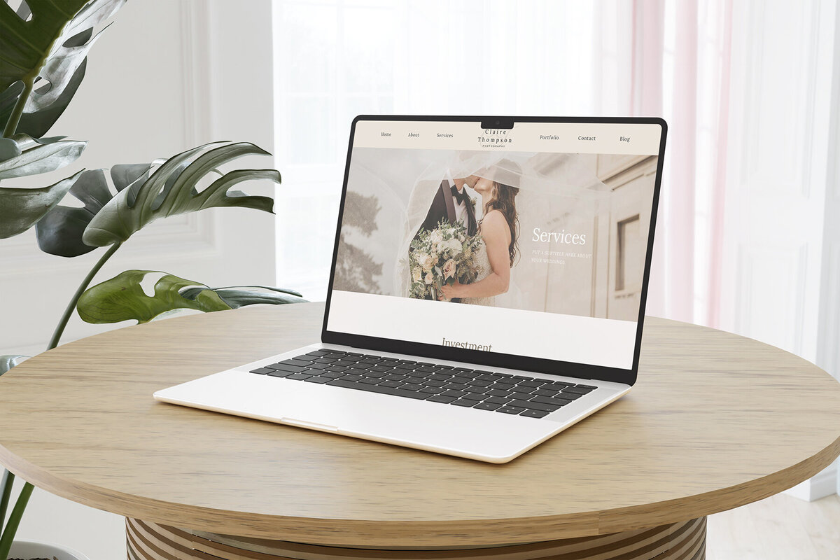 picture of a laptop sitting on a table with the claire thompson showit website template on the screen