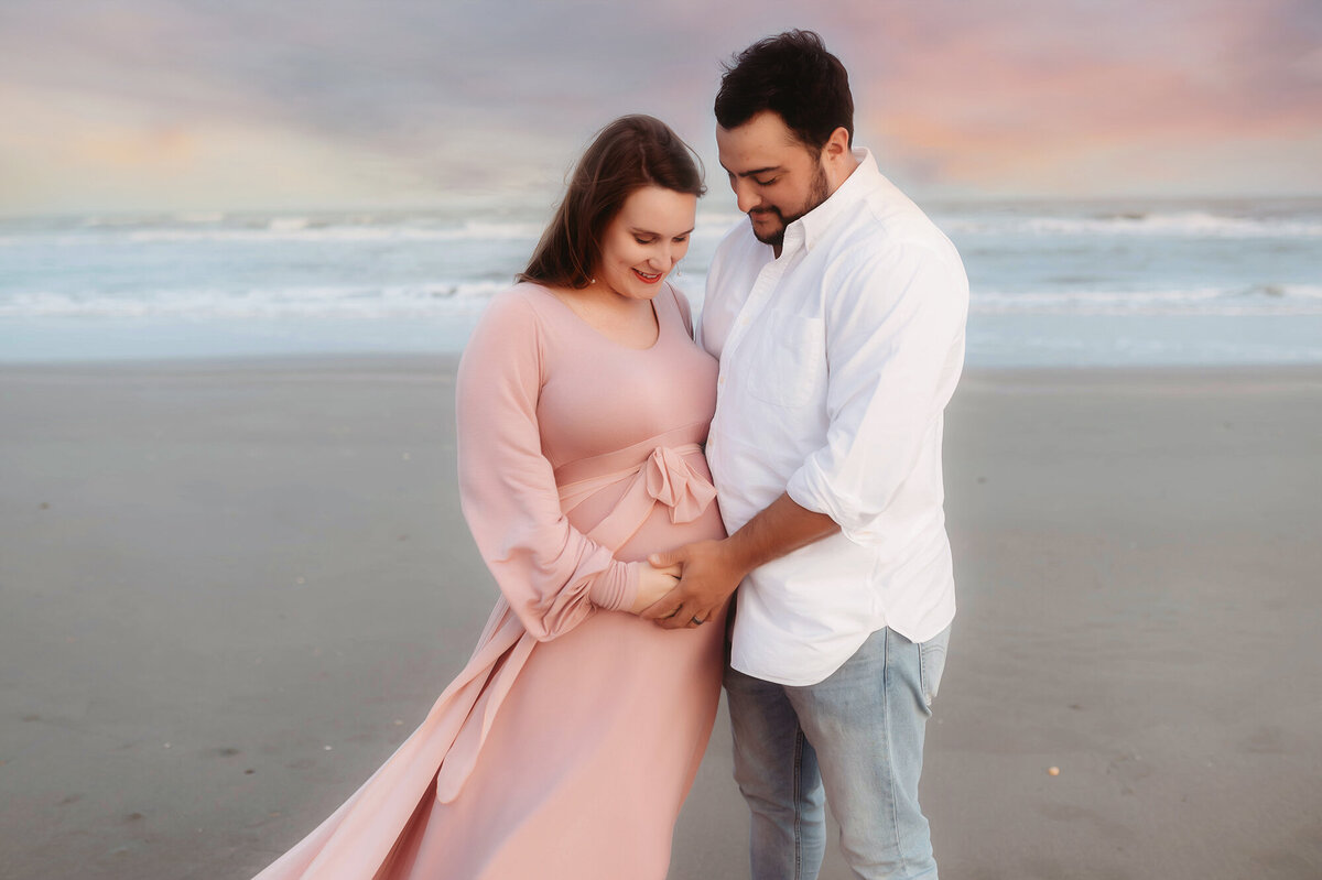 During their Babymoon in Charleston, expectant parents pose for Beach Maternity Photos in Charleston, SC.