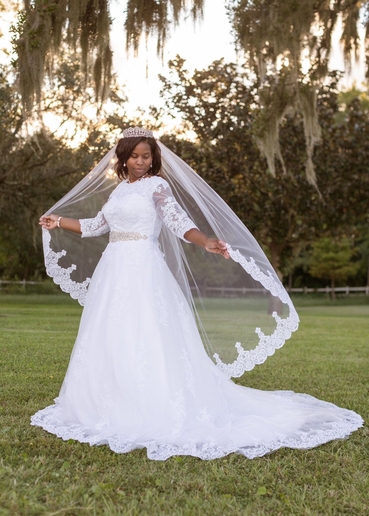 A bride holds her vail in the wind at The Old Place in Gauthier, Mississippi.