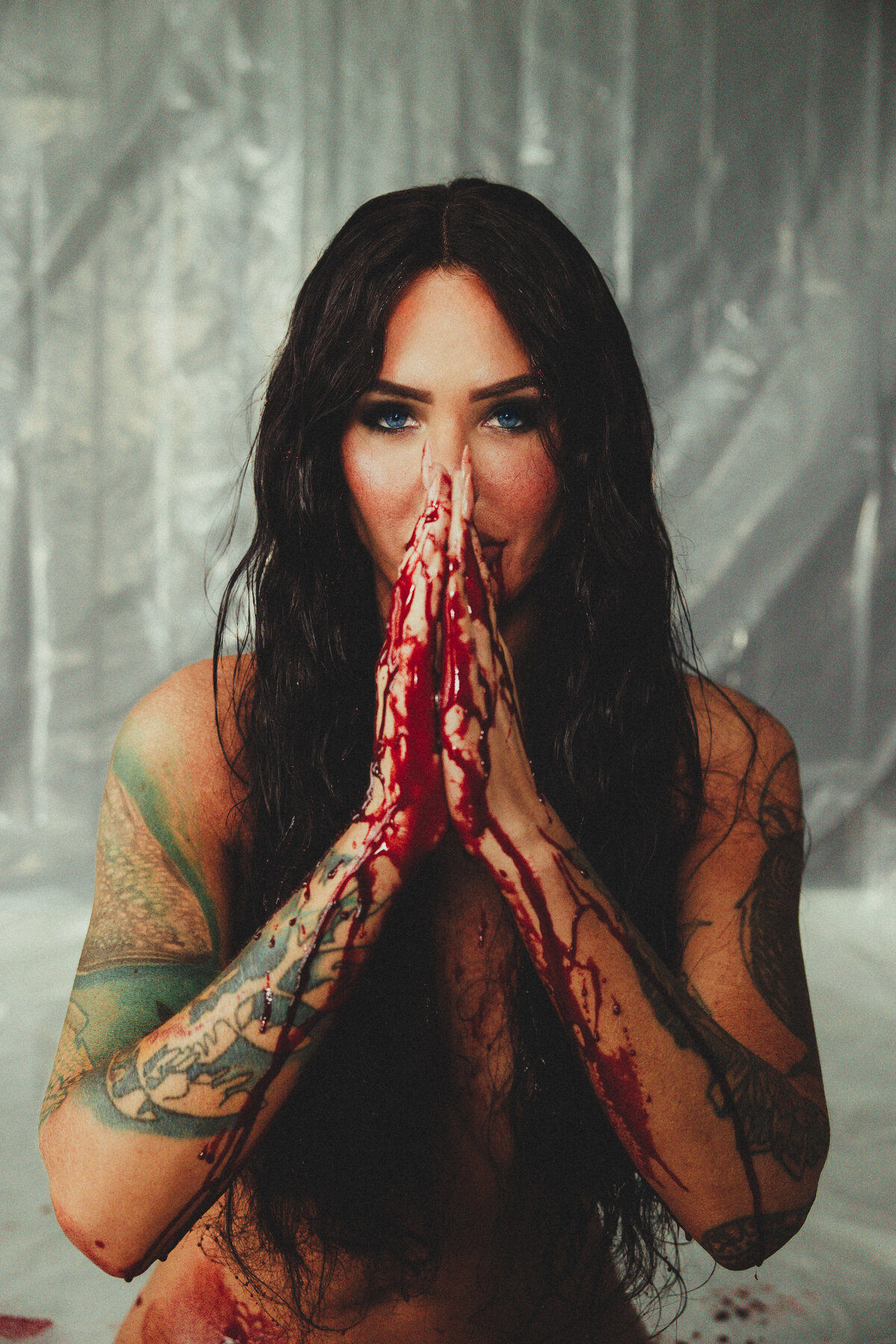 With hands pressed in a prayer pose, this dramatic portrait balances beauty, tension, and emotion in a bold conceptual style.