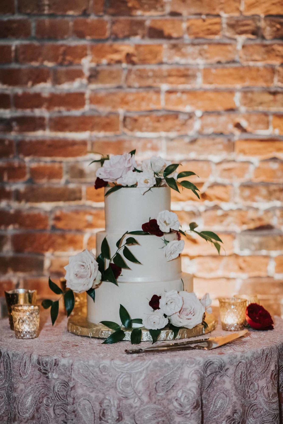wedding cake in front of brick wall