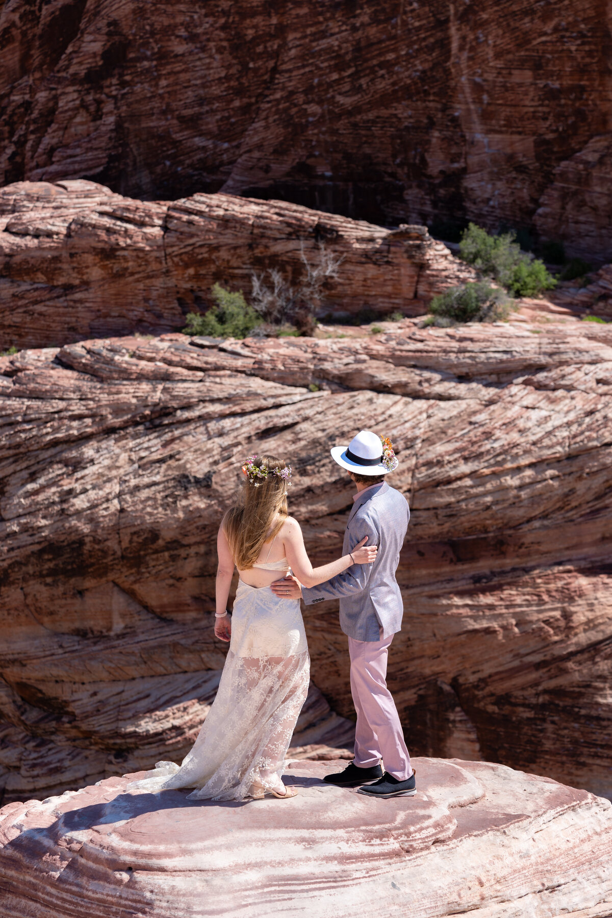 A newlywed couple standing on rocks together