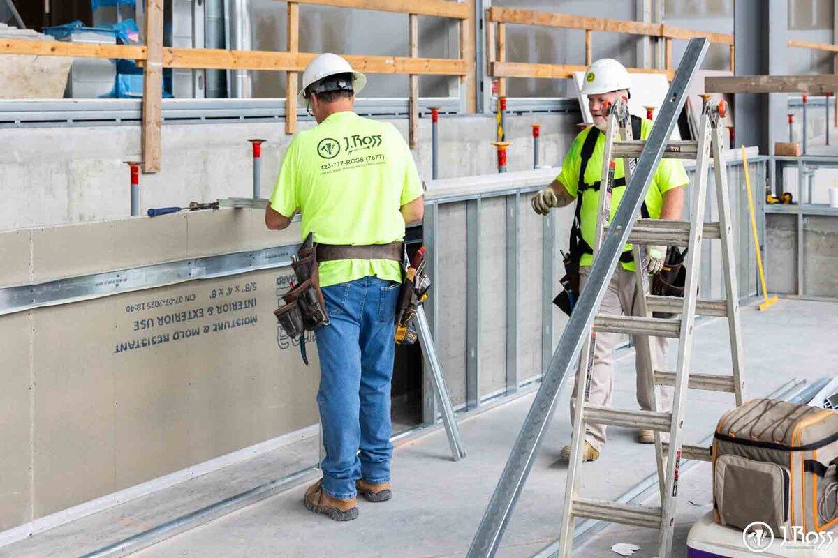 A J.Ross Painting & Drywall technician performing drywall installation on a new higher education building project.