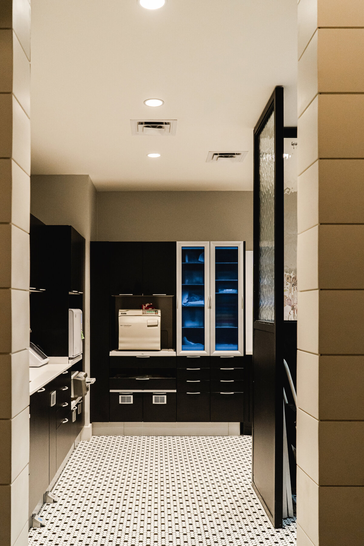 dentist and dental hygienist workroom with black cabinets and black and white tile flooring