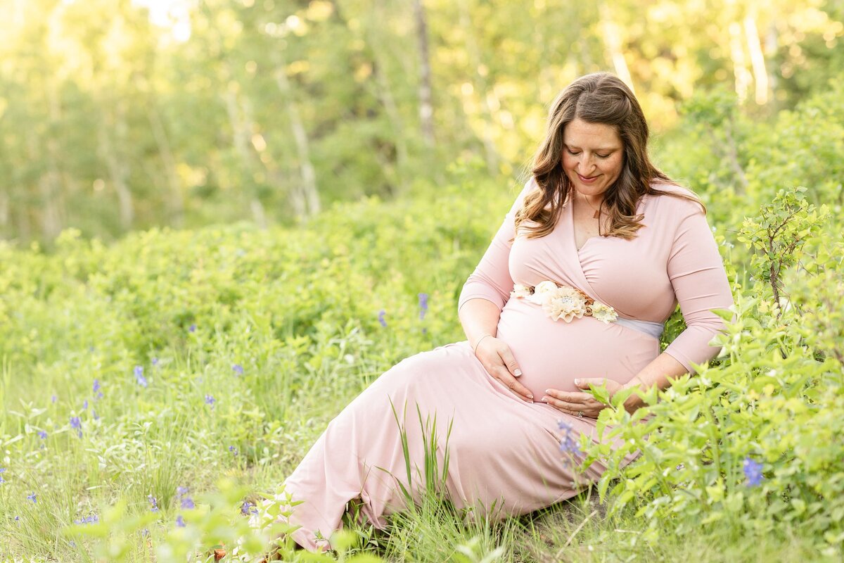 a pregnant woman sitting in a field