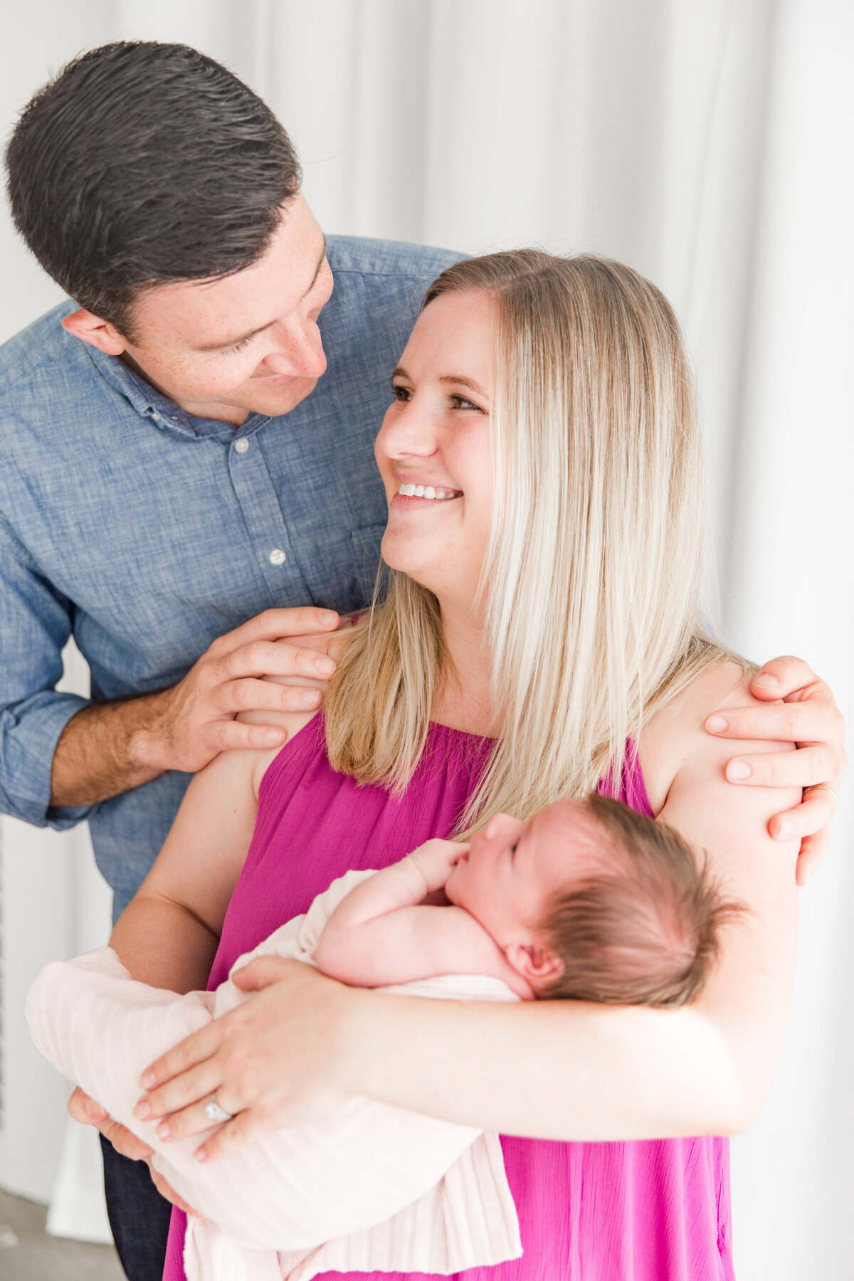 Newborn session mom holds baby and looks at dad. Sugarhill Studio Longmont CO