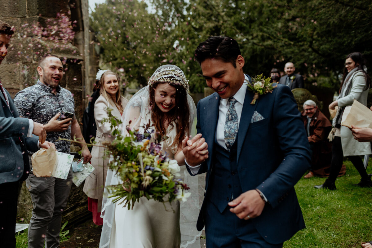 bride and groom walking under confetti
