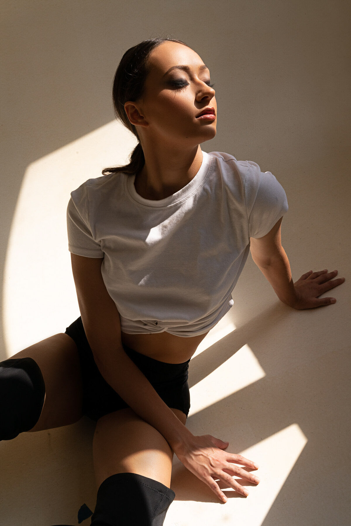 Model with radiant, dewy skin and slicked-back hair – editorial look by Lyds Makeup in the New York City area.