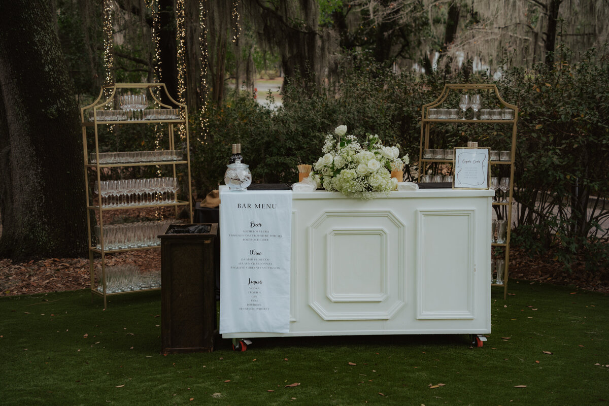 Bar setup on the side porch with signature cocktails and custom signage