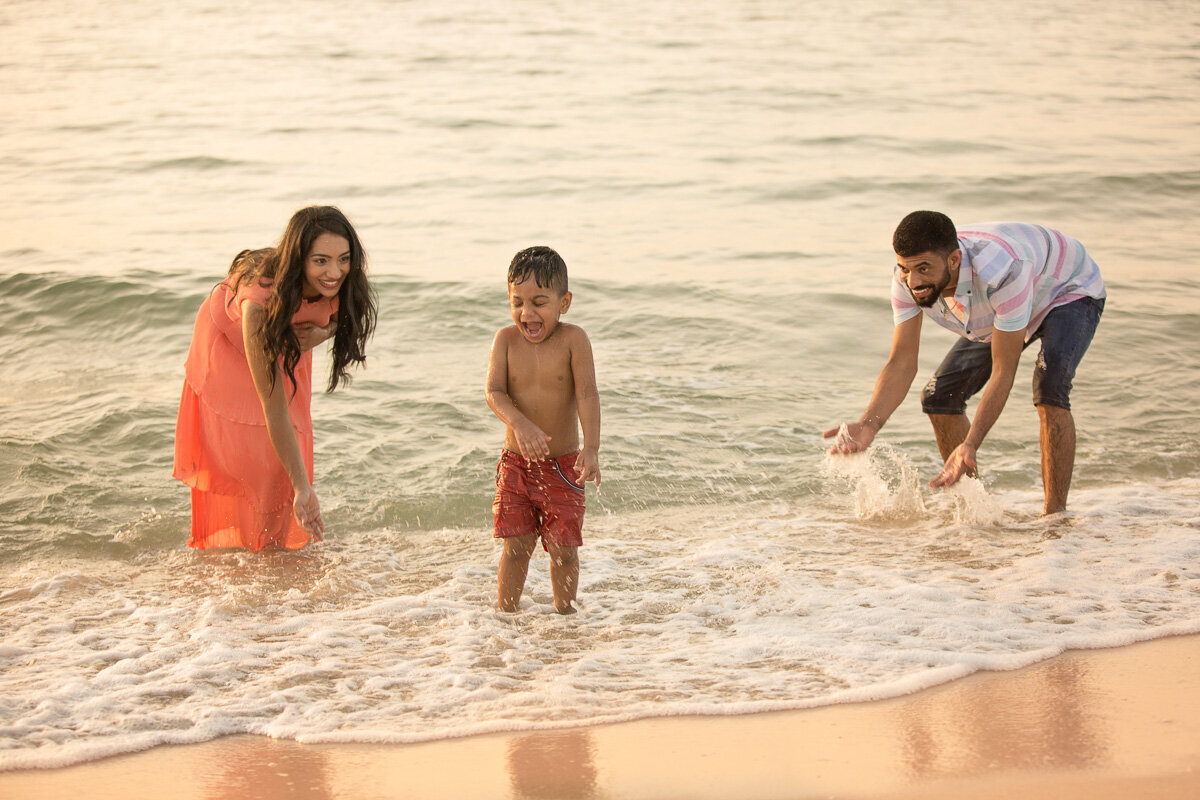 parents-splashing-baby-boy-in-the-sea