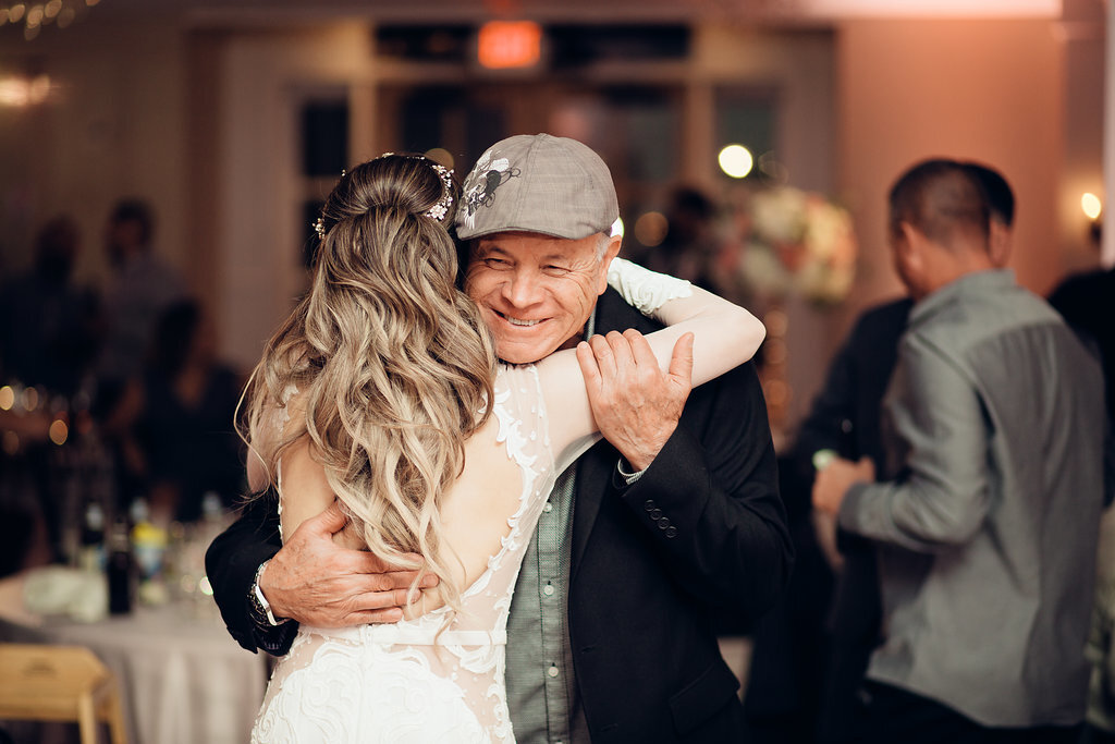 Wedding Photograph Of Bride Hugging a Man In Black Suit And Gray Cap Los Angeles