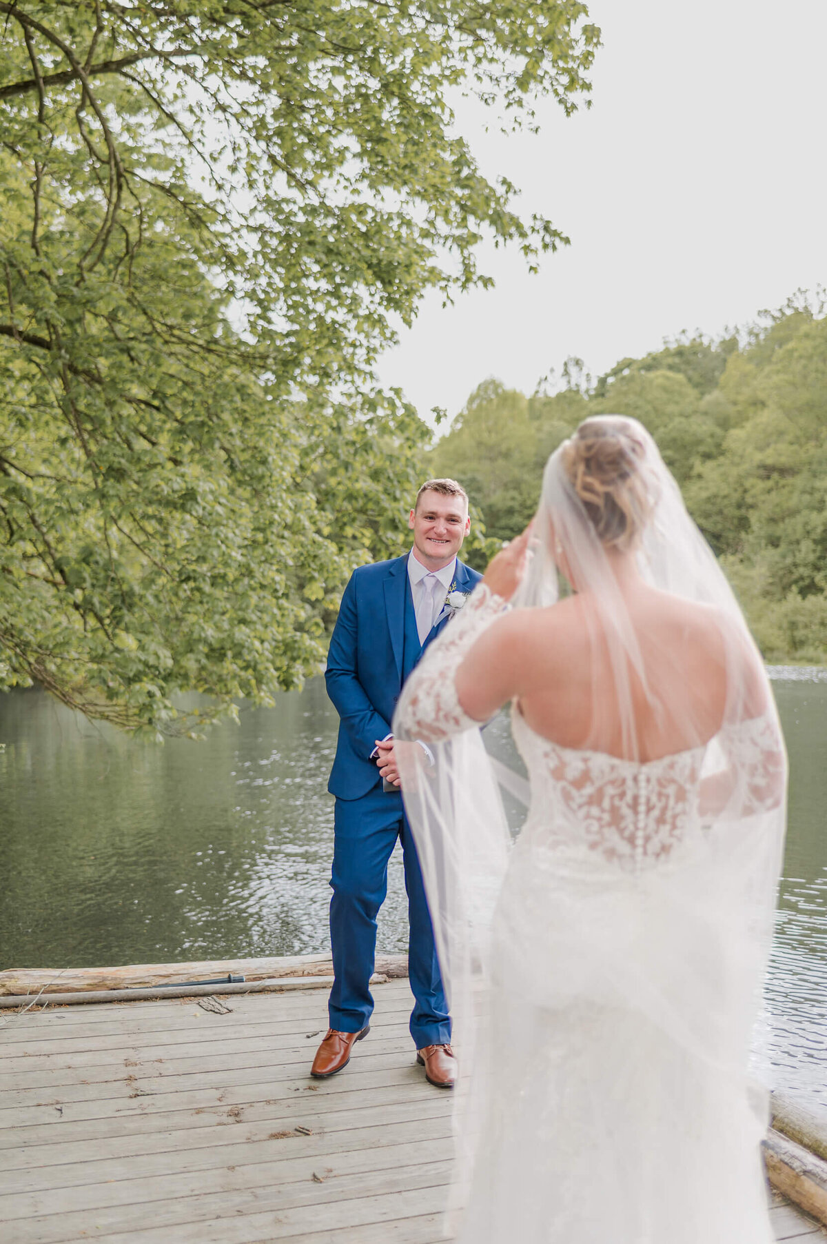 Groom reacts to seeing his bride during their first look by the water,  captured by Pittsburgh wedding photographer Bree Stewart of LLP.