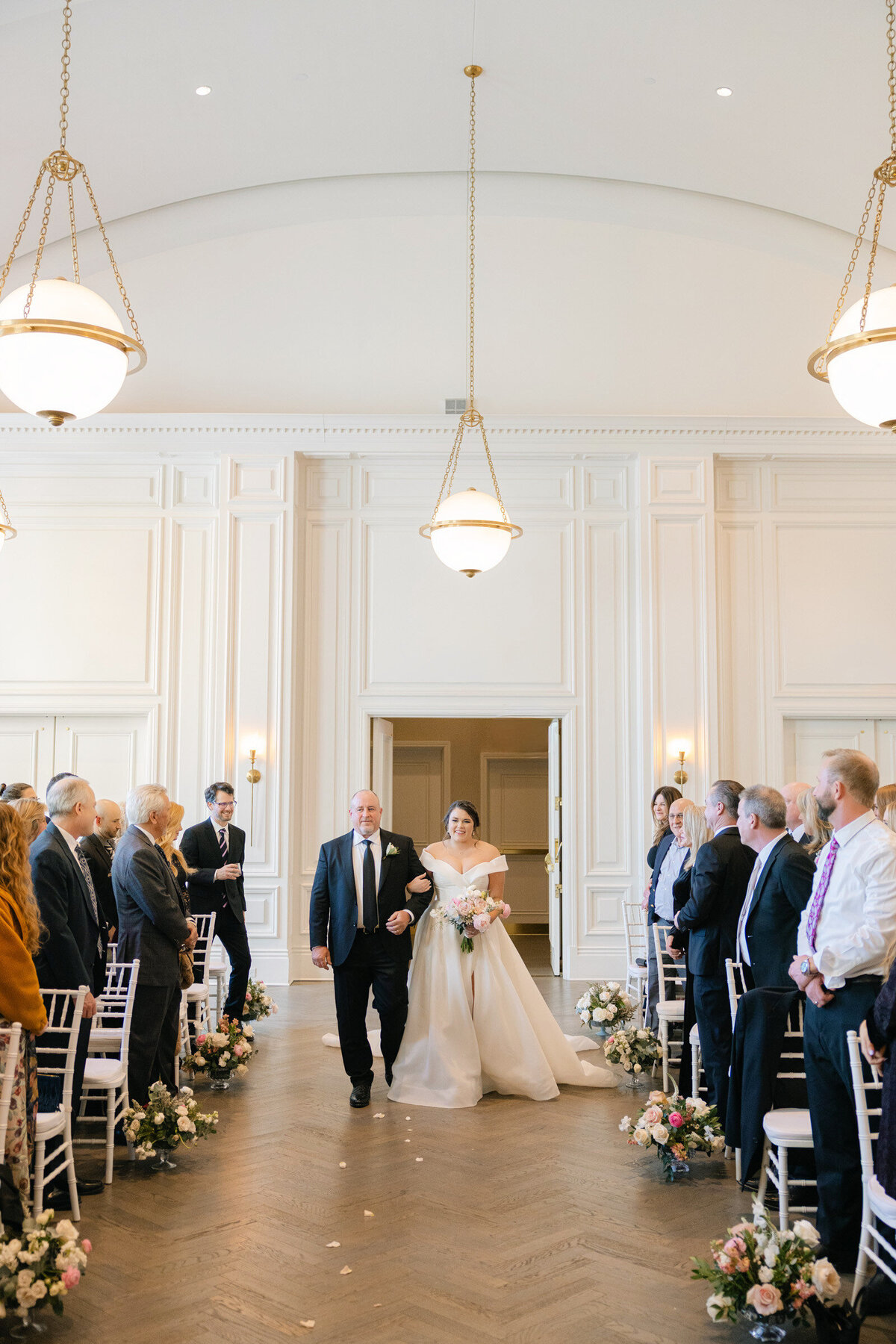 parents walking down the aisle as the wedding ceremony begins in the Governor’s Room at The Adolphus in Dallas, capturing a heartfelt and elegant moment.
