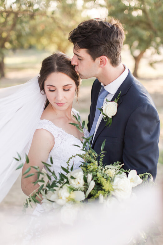 bride and groom in almond grove with flying veil