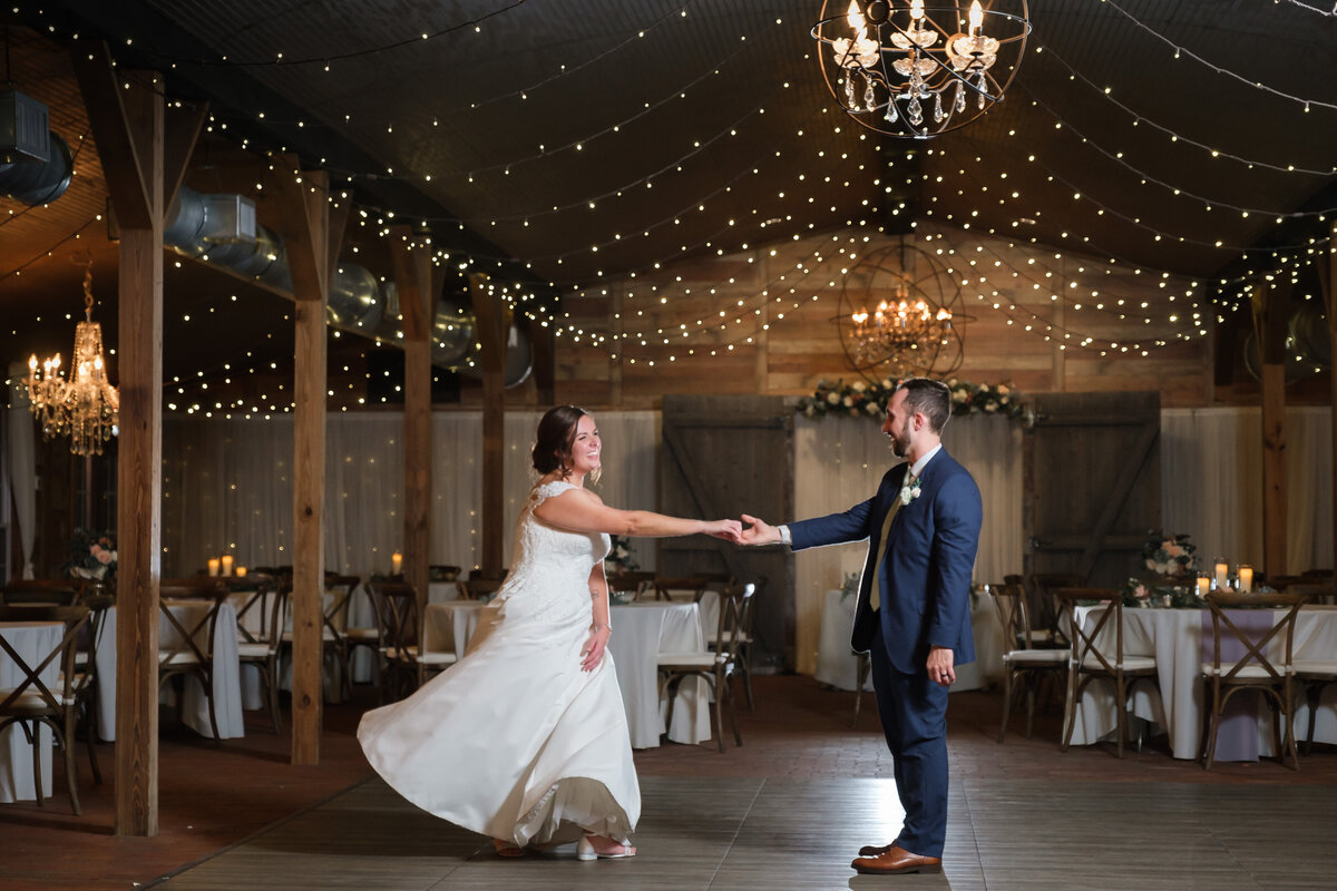 Bride and Groom share a last dance in the Cross Creek Ranch Barn alone under the string lights