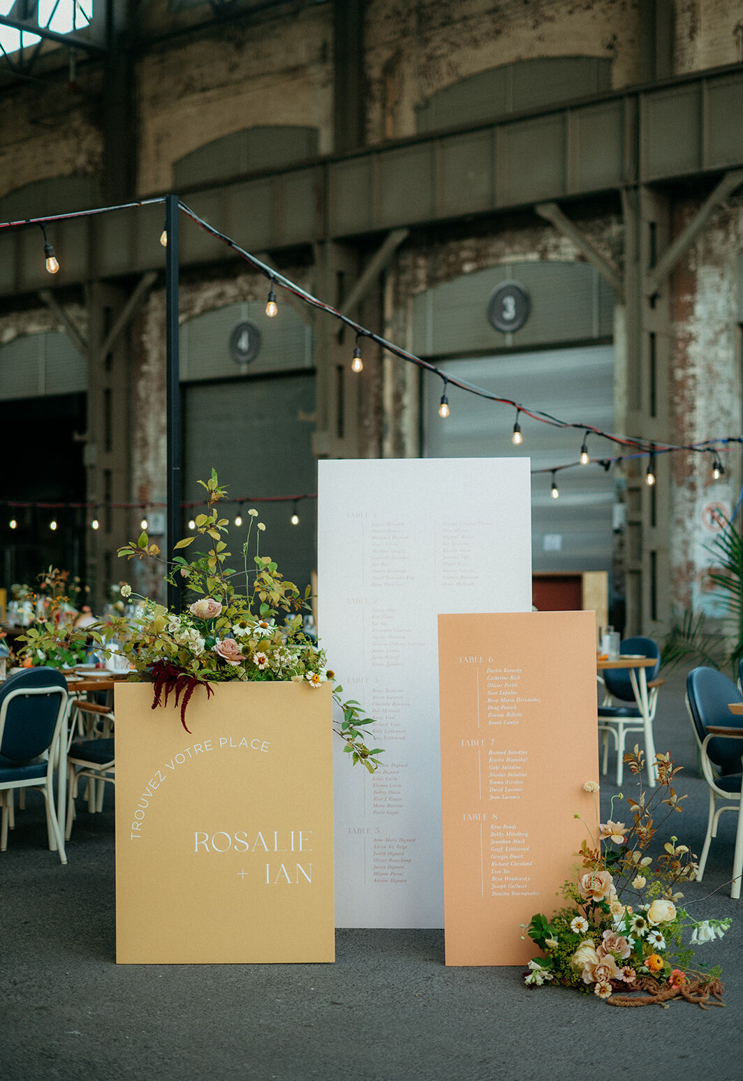 Two flower arrangements top a place card display at a Hoogan et Beaufort restaurant in Montreal.