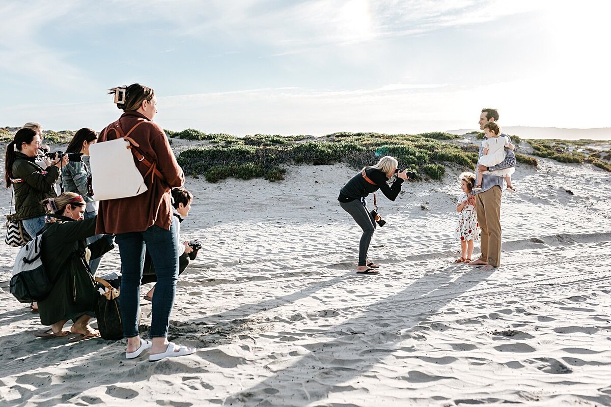 A family photographer leads a session for photography students on Coronado Beach in San Diego