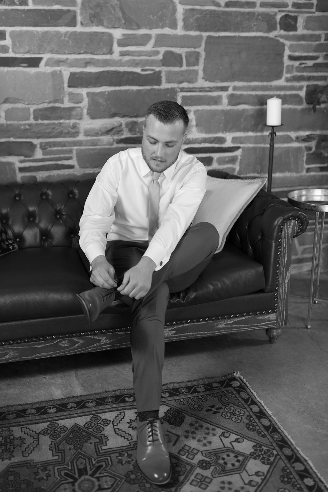 groom tying shoes getting ready at upstate wedding venue