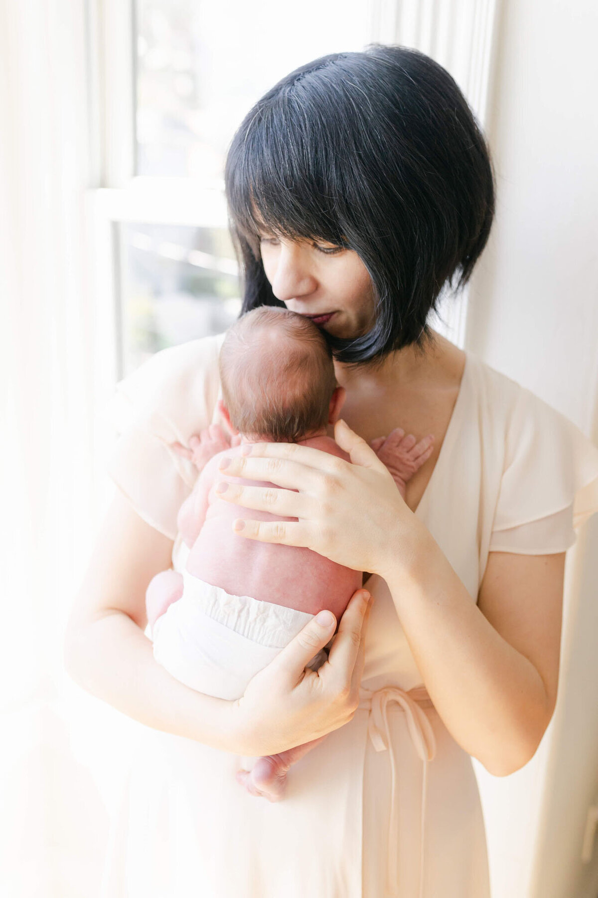 Mom cuddling their newborn during an in-home San Francisco Bay Area newborn photographer session.