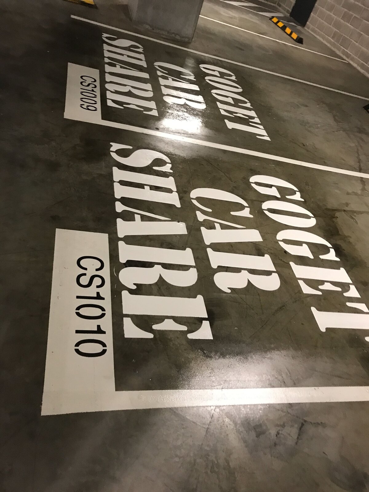 Line marking letters on concrete carpark floor "Goget Car Share"