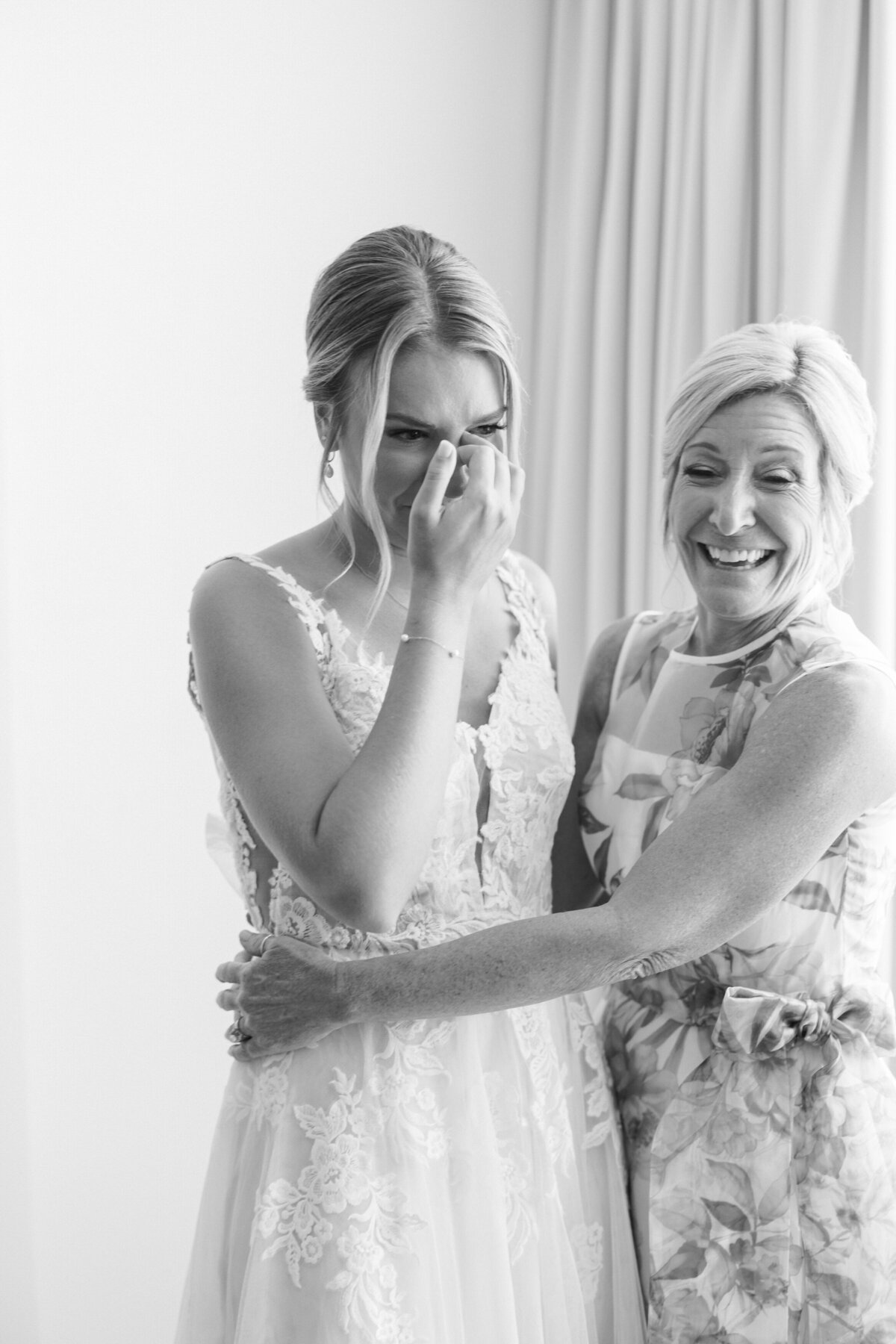 Emotional bride wiping tears with her mom in Cancun bridal suite, by Philadelphia destination wedding photographer.