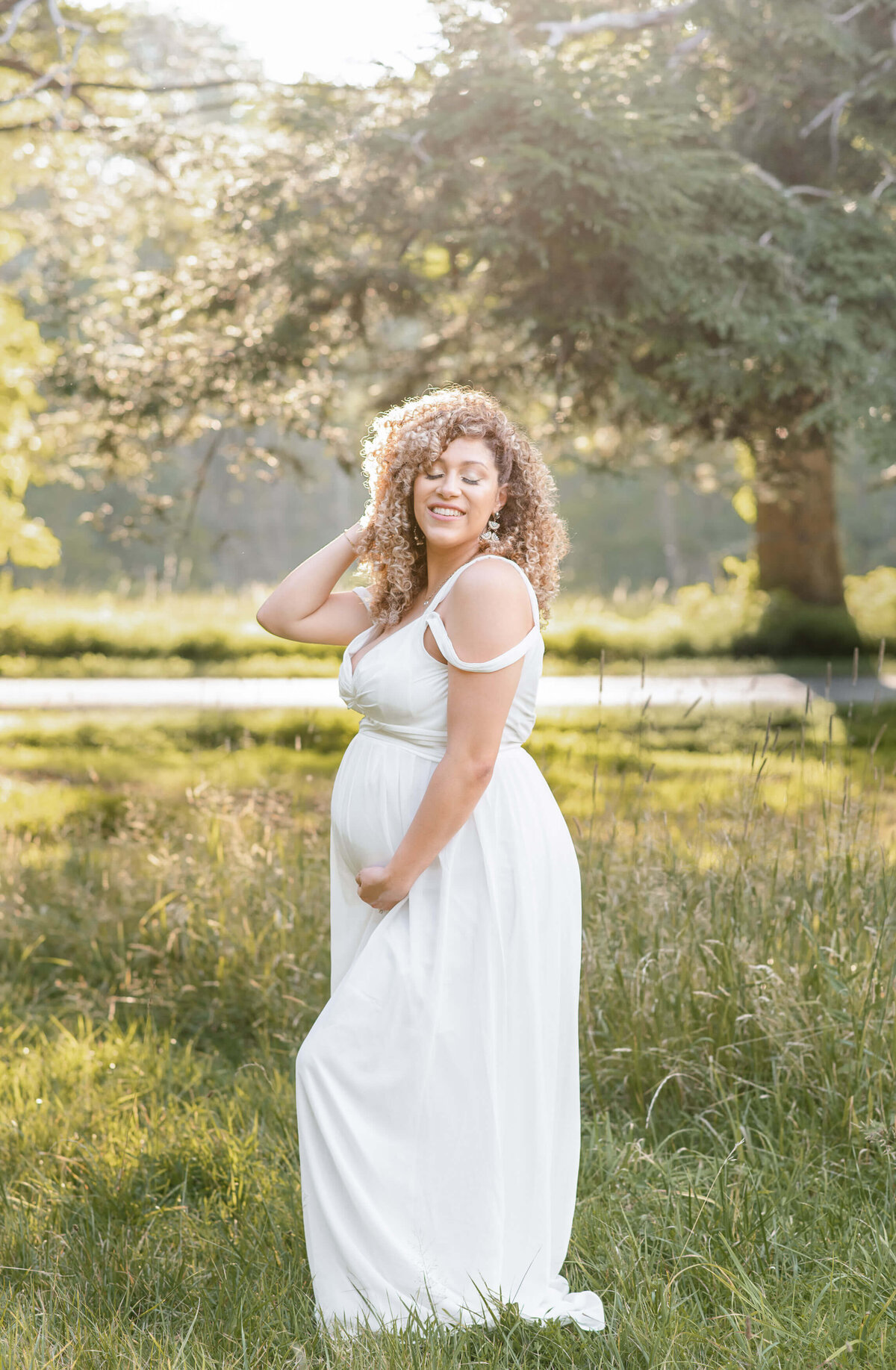 30 weeks pregnant woman on a field smiling enjoying a spring day