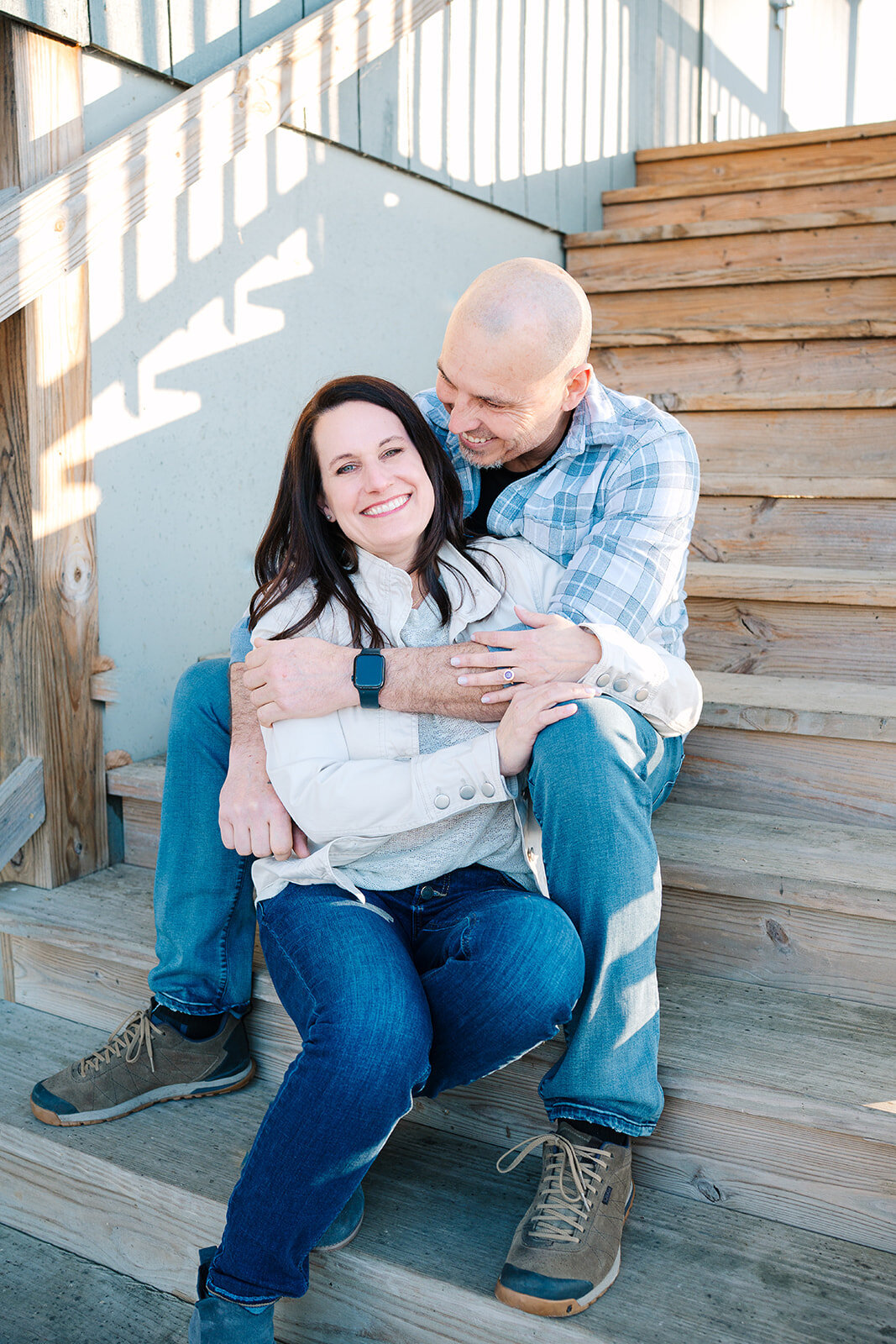 A couple sitting on a staircase with their arms around each other 