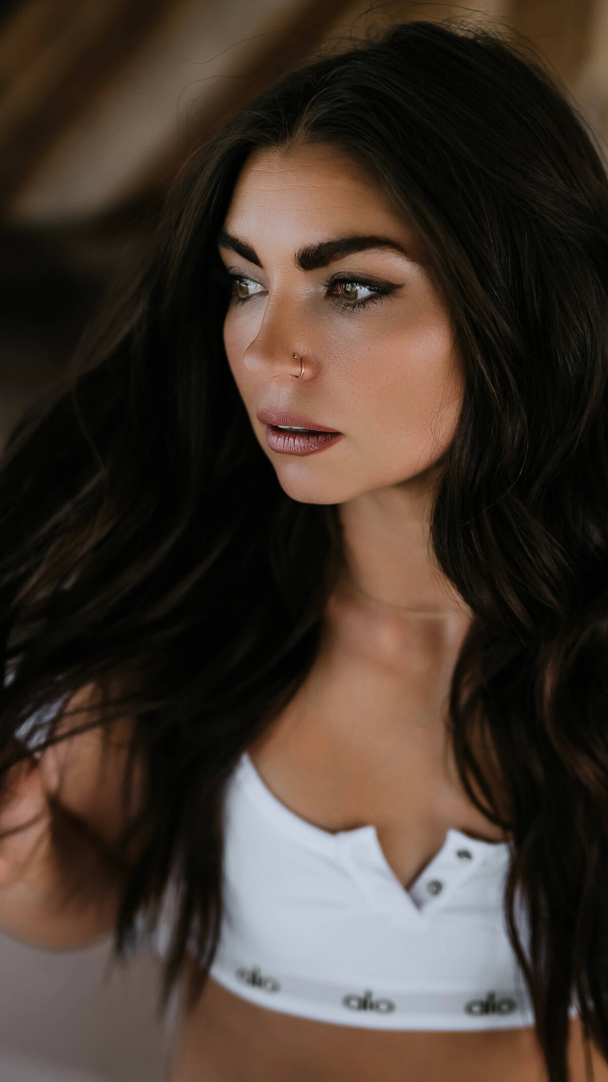 A sporty close up image of a dark brown hair woman posing in white lingerie