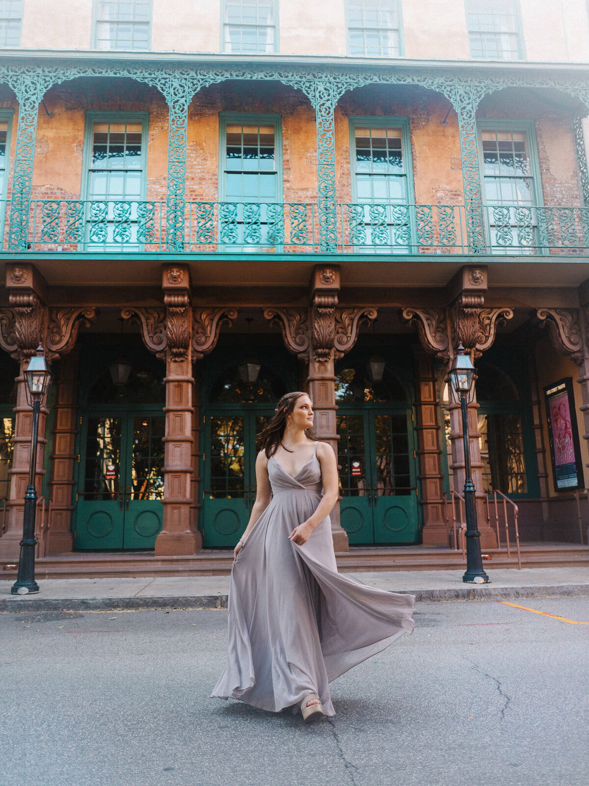 Teen girl walking in front of colorful storefront during senior portraits in downtown Charleston, SC