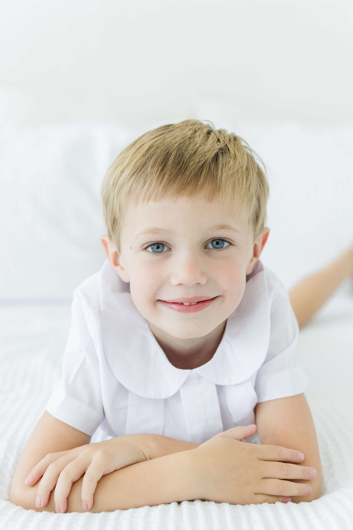 boy looking into camera smiling with arms crossed  for milestone photography
