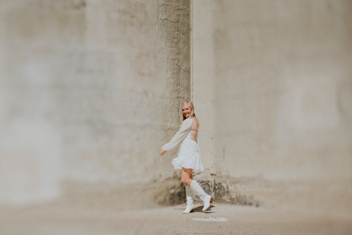 Female senior portrait dancing in the sun light in minneapolis