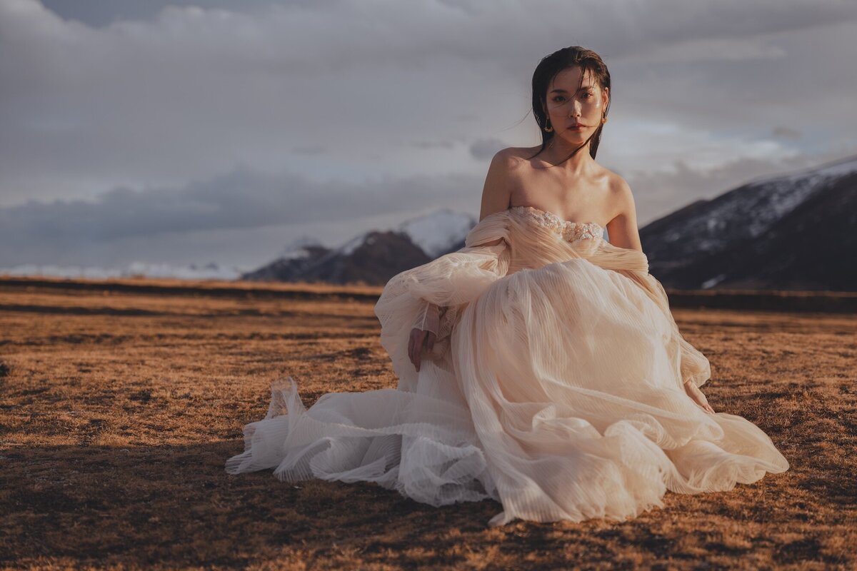 A bride photographed in a couture dress in the hills of Queenstown.