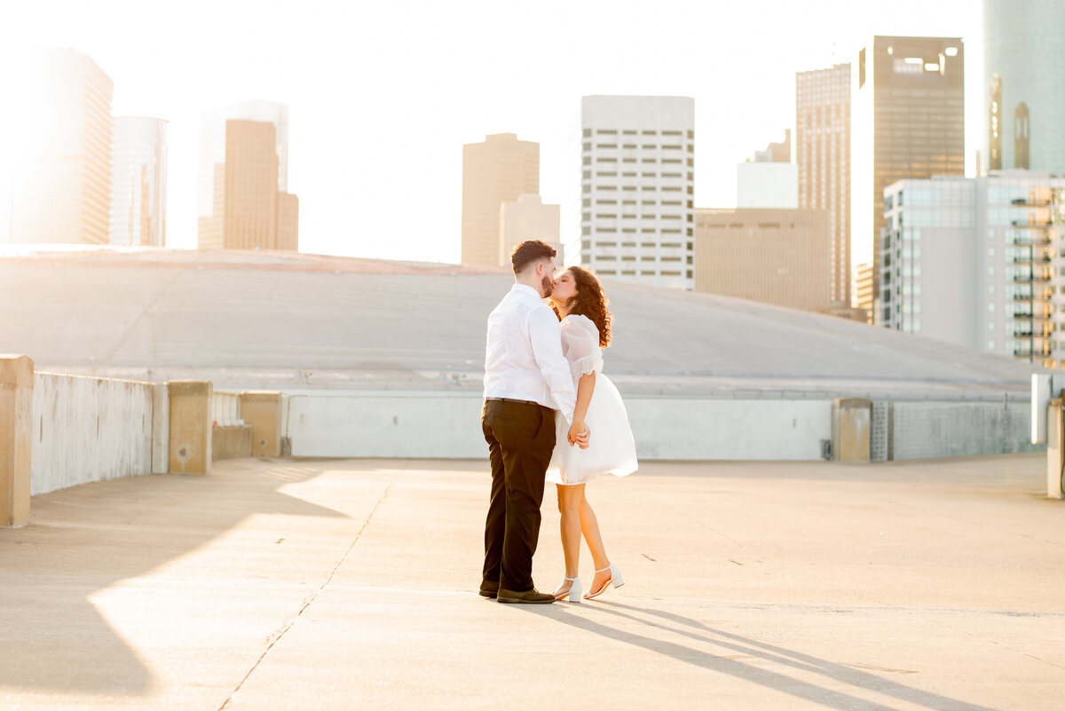 Elevate your love story with a breathtaking engagement photo on a Houston rooftop, where the cityscape provides a stunning backdrop to your romantic journey