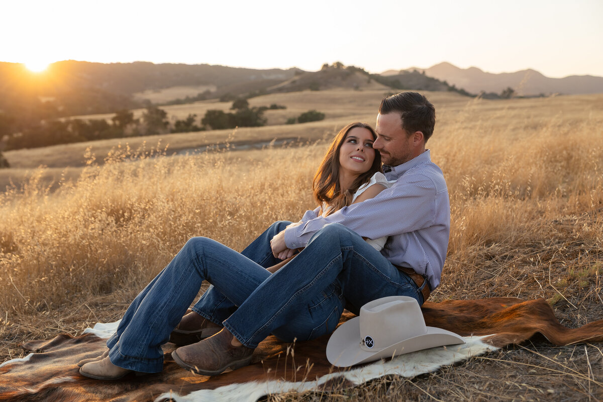candid couples engagement photos in open field during golden hours in San Luis Obispo