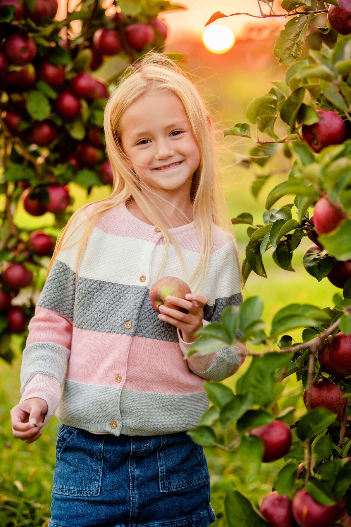 Little girl standing near an apple tree for her Burlington fall family photography session