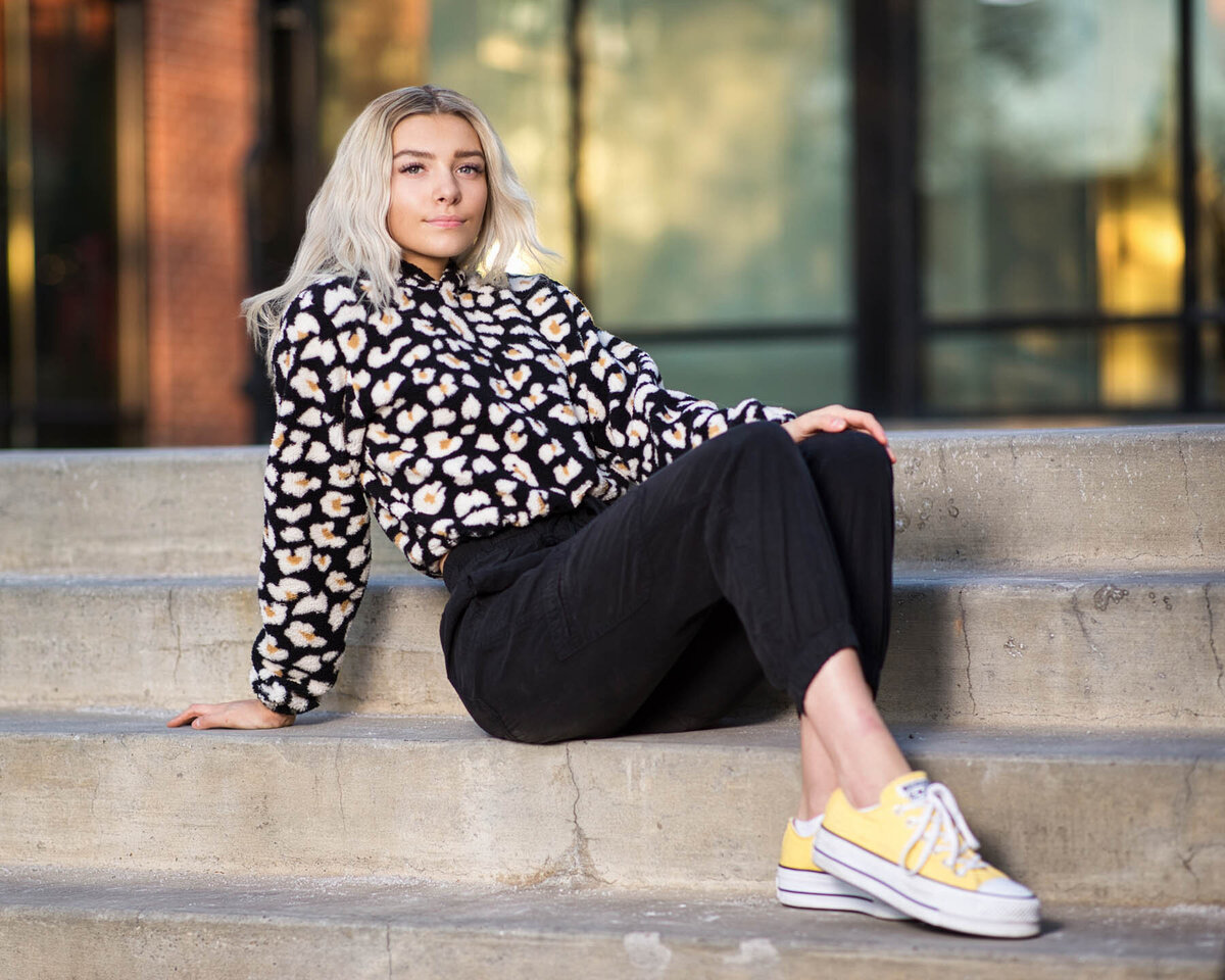 Senior photo taken of girl posing on stairs with yellow converse shoes in Utah.