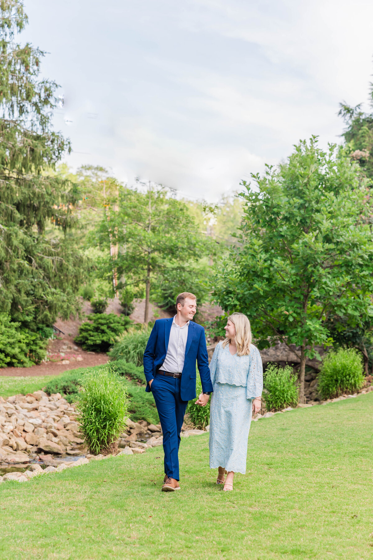 couple walking hand in hand at park in greenville, south carolina