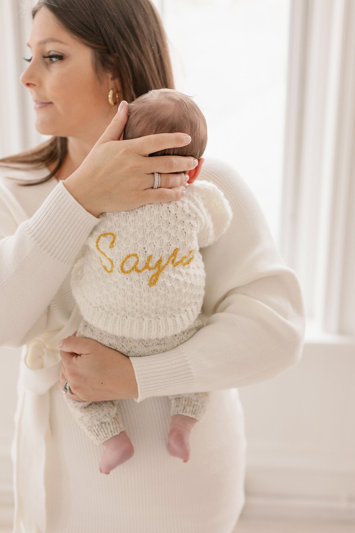 Mother holds child during newborn session in boston.