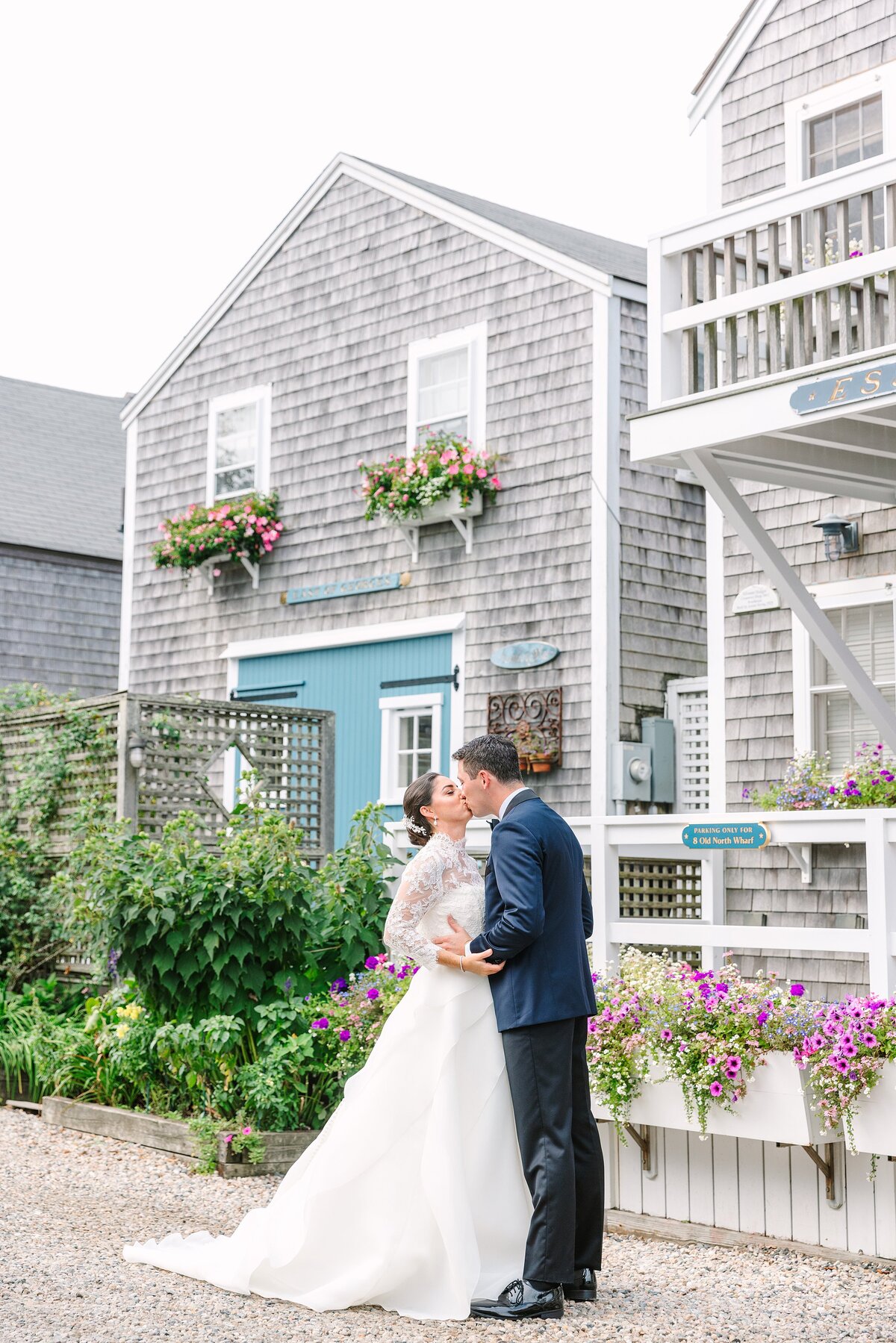 bride and groom kiss on old north wharf in nantucket